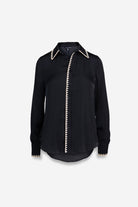 Black shirt with white trim on a light gray background