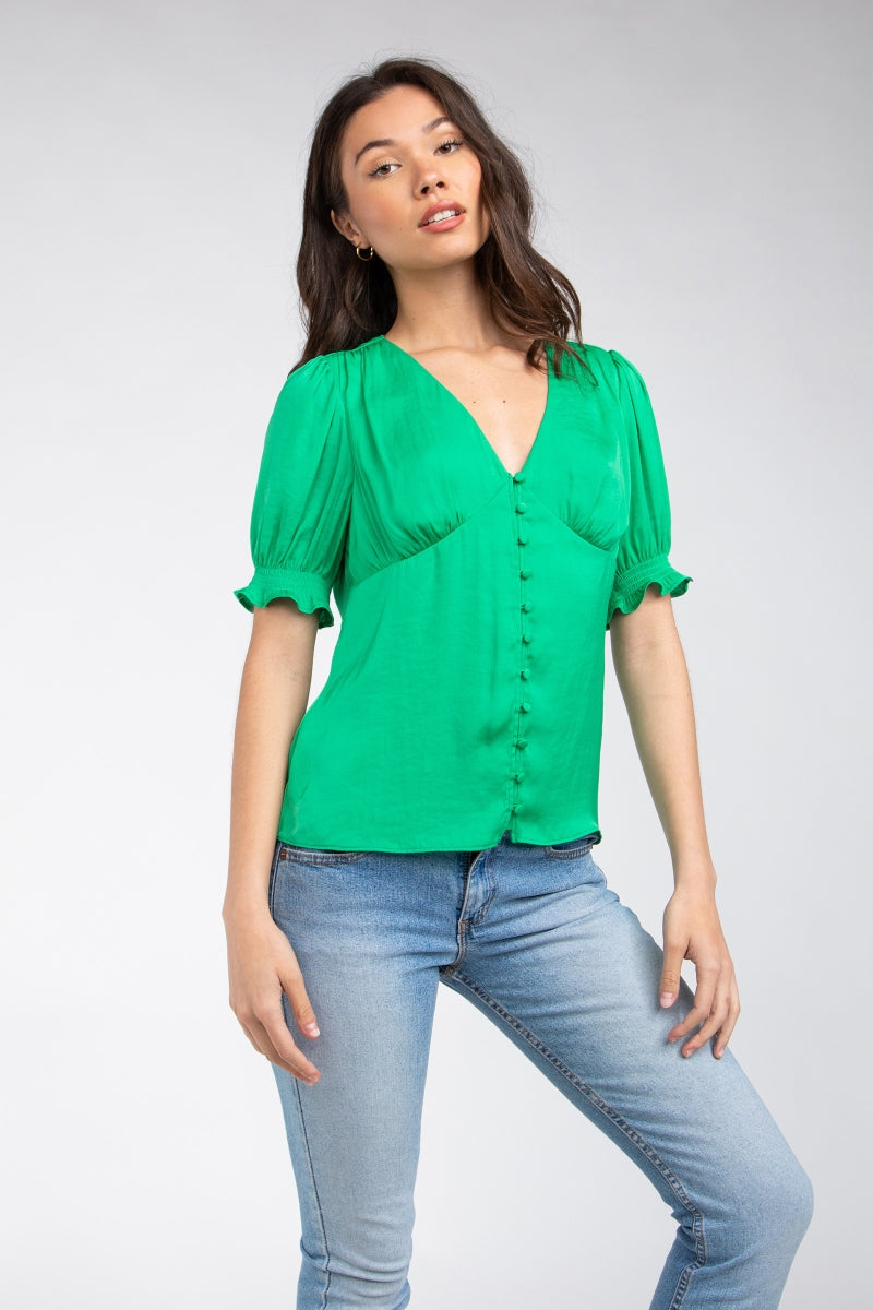 Woman wearing a green blouse and blue jeans on a white background